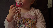 Orianne a rejoint le concours — aidez-le/la à gagner de superbes lots ! toddler, pacifier, pajamas, child, indoor, sofa, couch, home, cute, girl, clothing, sitting, heart_pattern, face, person, hand, toy, relaxing, young_child, comfort