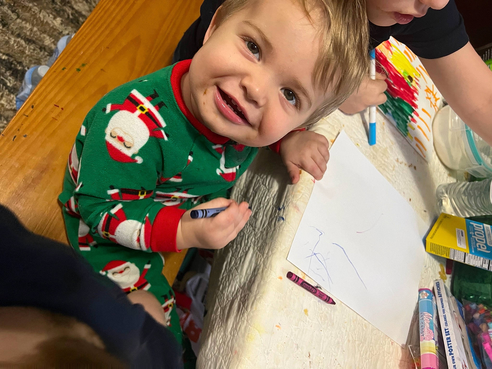Kayden is registered to the contest to win money with this photo: child, christmas, education, event, face, fun, happy, holiday, joy, leisure, person, play, reading, room, sitting, smile, t_shirt, toddler, tree, visual_arts