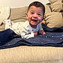 Sohan a rejoint le concours — aidez-le/la à gagner de superbes lots ! baby, smiling, infant, onesie, blanket, couch, indoor, happy, face, child, cute, lying_down, cozy, home, furniture, patterned_clothing, star_pattern, toddler, joyful, portrait