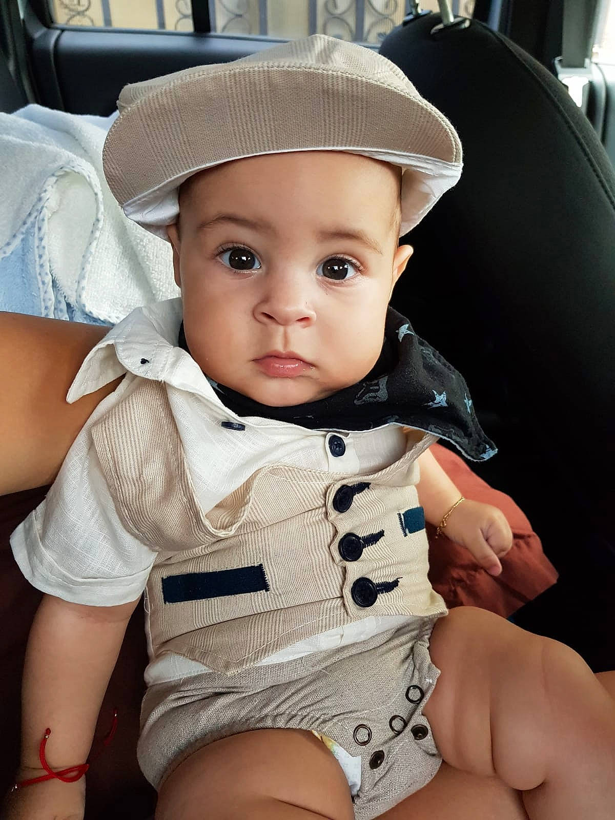 Emanuel is registered to the contest to win money with this photo: abdomen, baby, cheek, child, eye, fashion_accessory, finger, hand, hat, headgear, headwear, leg, neck, person, product, sitting, skin, sun_hat, thigh, toddler
