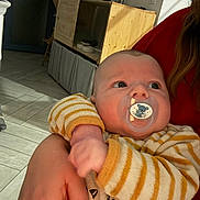 Owen participe au concours pour gagner de l'argent avec cette photo : baby, cabinet, child, cozy, cute, door, face, floor, furniture, hand, holding, indoor, infant, light, pacifier, person, skin, striped_clothing, warm, wood