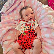 Caroline joined the competition — help win amazing prizes! baby, infant, smiling, blanket, pink, white, clothing, ladybug, pattern, cute, soft, happy, indoor, person, child, legs, face, hair, toddler, cozy