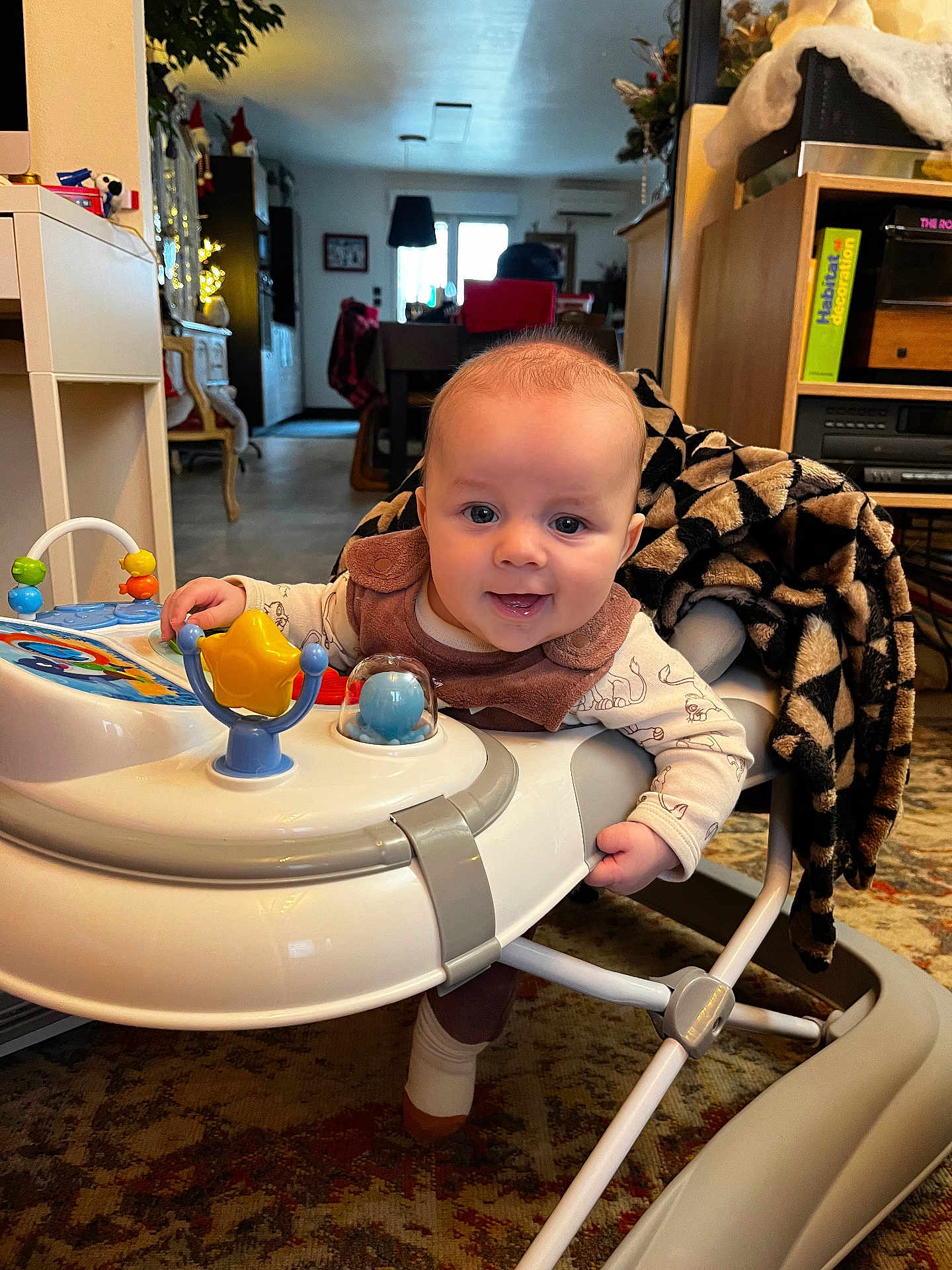 Isaac a rejoint le concours — aidez-le/la à gagner de superbes lots ! baby, walker, toy, indoor, living_room, smile, child, face, furniture, blanket, carpet, person, home_decor, play, cute, happy, young_child, clothing, floor, cozy
