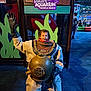Ezra is registered to the contest to win money with this photo: child, diving_suit, aquarium, ripley, play_area, sign, indoor, blue_floor, metal, vintage, exhibit, people, family, fun, museum, curious, smiling, waving, helmet, display