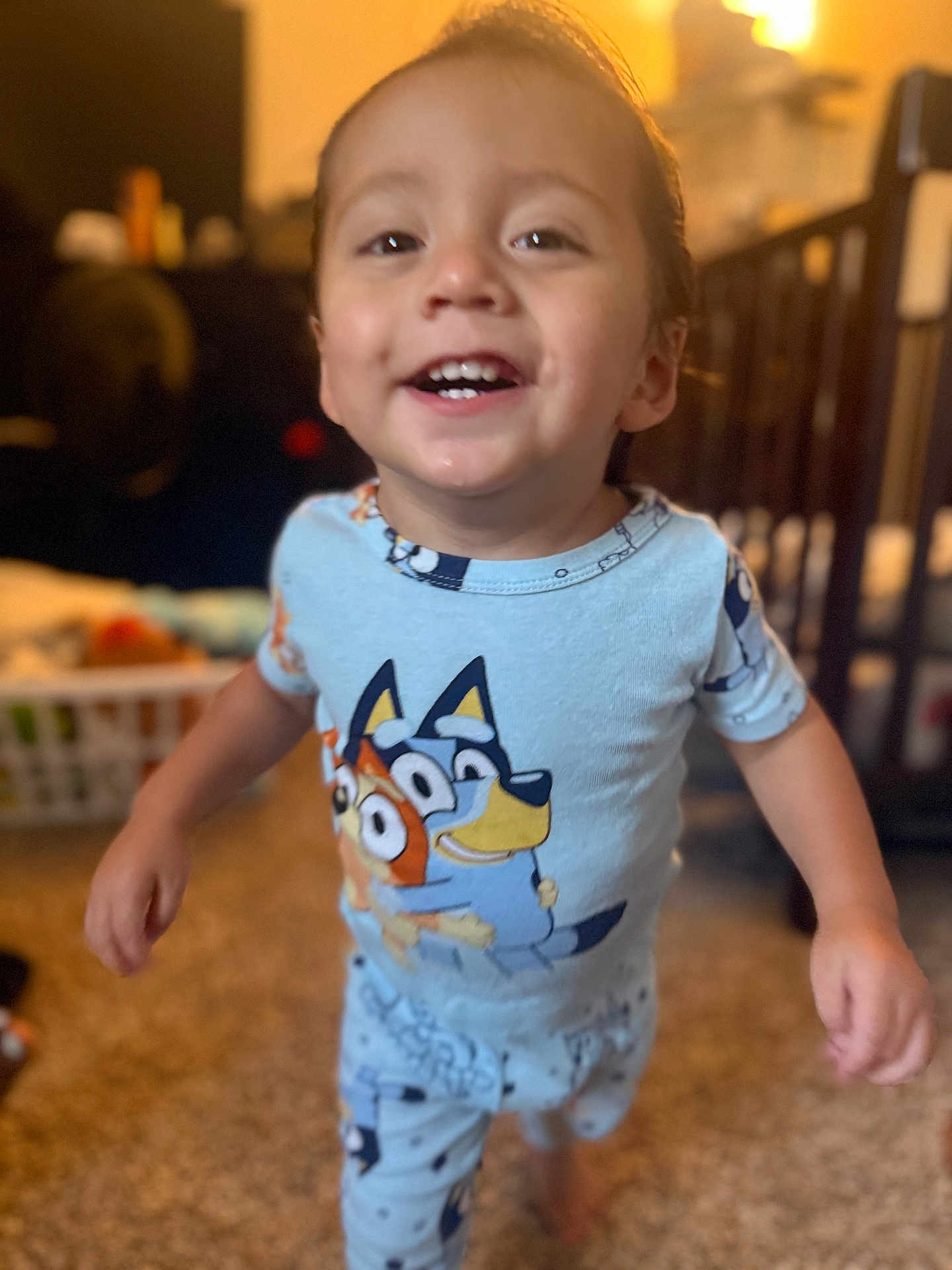 Ezra joined the competition — help win amazing prizes! toddler, child, smiling, pajamas, blue, indoor, carpet, face, person, cute, happy, walking, clothing, home, bedroom, toy, furniture, blurred_background, young_child, playful