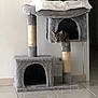 cat, tabby_cat, cat_tree, pet_furniture, indoor, tile_floor, blanket, curious, animal, feline, cozy, cubby, gray, home, domestic_cat, resting_place, household, play_structure, wall, floor