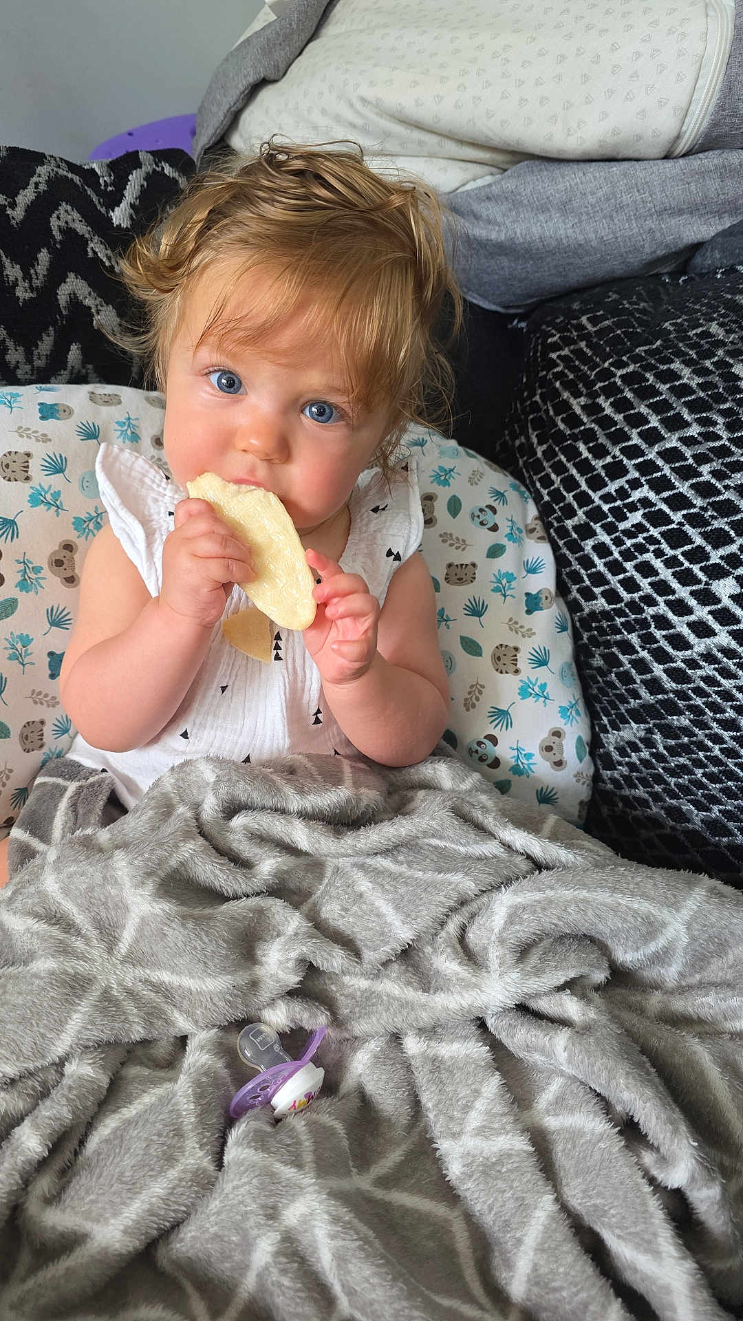 Alina joined the competition — help win amazing prizes! toddler, child, blue_eyes, snack, blanket, pacifier, couch, cushions, white_clothing, curly_hair, indoor, portrait, baby, comfort, cozy, food, cute, sitting, young_child, relaxed