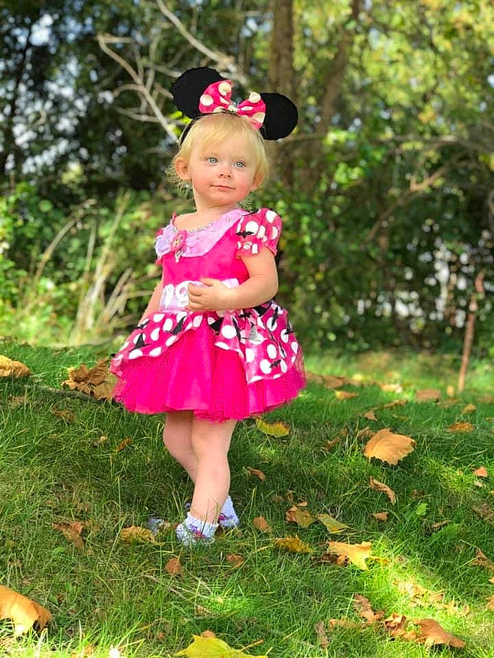 Agnes joined the competition — help win amazing prizes! baby_toddler_clothing, botany, clothing, day_dress, dress, fawn, grass, grass_family, grassland, happy, leaf, magenta, meadow, one_piece_garment, people_in_nature, person, petal, pink, plant, toddler