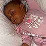 baby, sleeping, onesie, pacifier, pink_clothing, blanket, infant, cute, peaceful, child, indoors, soft_lighting, rest, sleep, toddler, skin, hand, face, pacifier_clip, bed