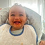 baby, messy_face, smiling, high_chair, bib, food, happy, infant, indoor, daylight, cute, child, small_hand, clothing, face, teeth, sitting, home, window, expression
