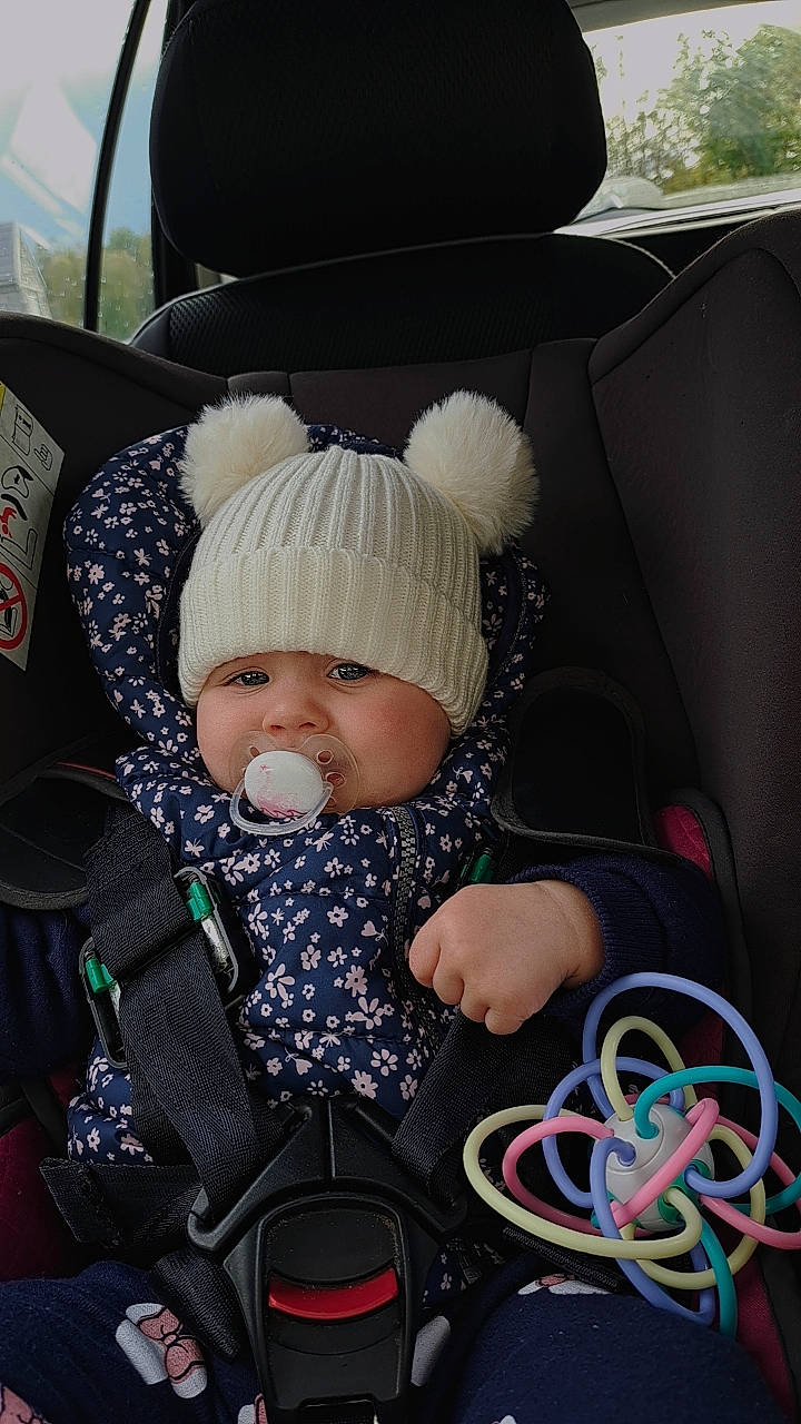 Mya participe au concours pour gagner de l'argent avec cette photo : auto_part, baby, baby_carriage, baby_products, baby_sleeping, baby_toddler_clothing, beanie, cap, car_seat, car_seat_cover, child, comfort, family_car, fashion_accessory, headwear, knit_cap, person, seat_belt, sitting, steering_wheel