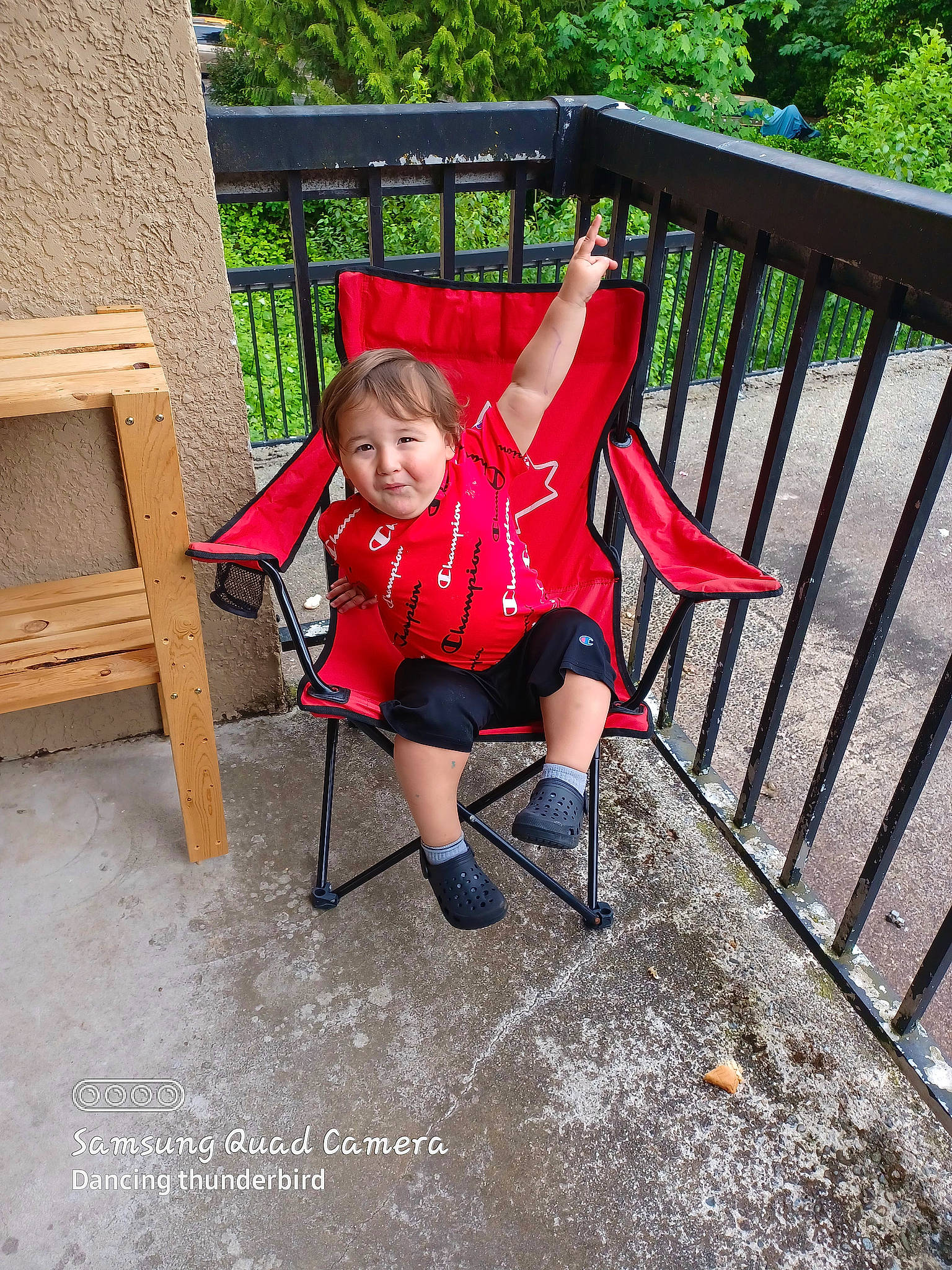 Ryland is registered to the contest to win money with this photo: baby_products, baby_toddler_clothing, carmine, chair, comfort, electric_blue, fence, fun, grass, leisure, magenta, outdoor_furniture, people_in_nature, person, plant, recreation, shorts, sitting, toddler, tree