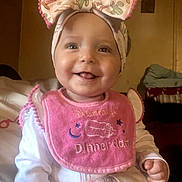 Embriona joined the competition — help win amazing prizes! baby, child, smile, headband, bow, bib, tattoo, hand, indoor, portrait, cute, happy, clothing, infant, person, face, warm_lighting, decor, room, sitting