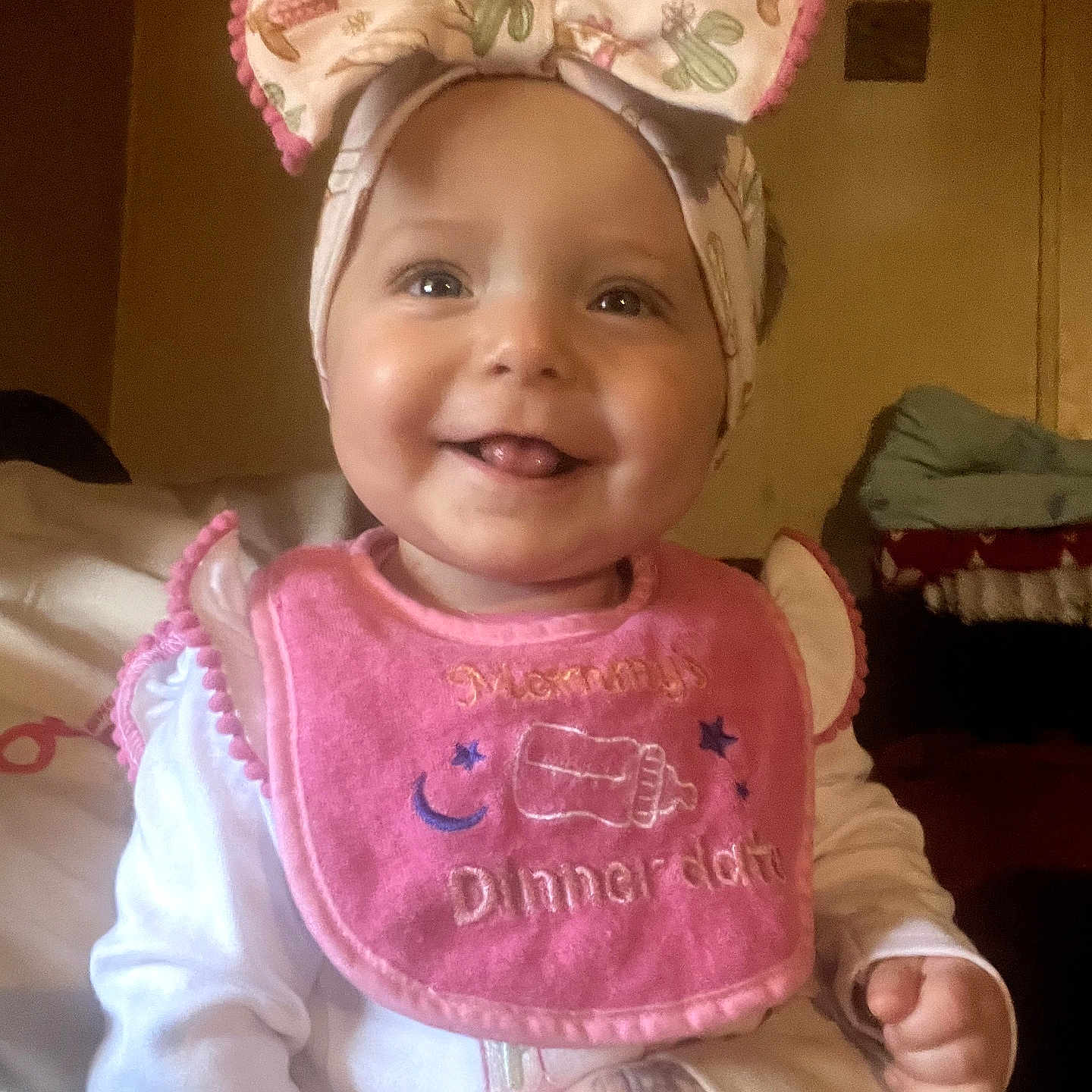 Embriona joined the competition — help win amazing prizes! baby, child, smile, headband, bow, bib, tattoo, hand, indoor, portrait, cute, happy, clothing, infant, person, face, warm_lighting, decor, room, sitting