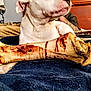 dog, white_dog, bone, bed, blanket, indoor, pet, furniture, person, relaxing, canine, chew_toy, resting, bedroom, headboard, tattoo, comfort, animal, domestic_animal, household