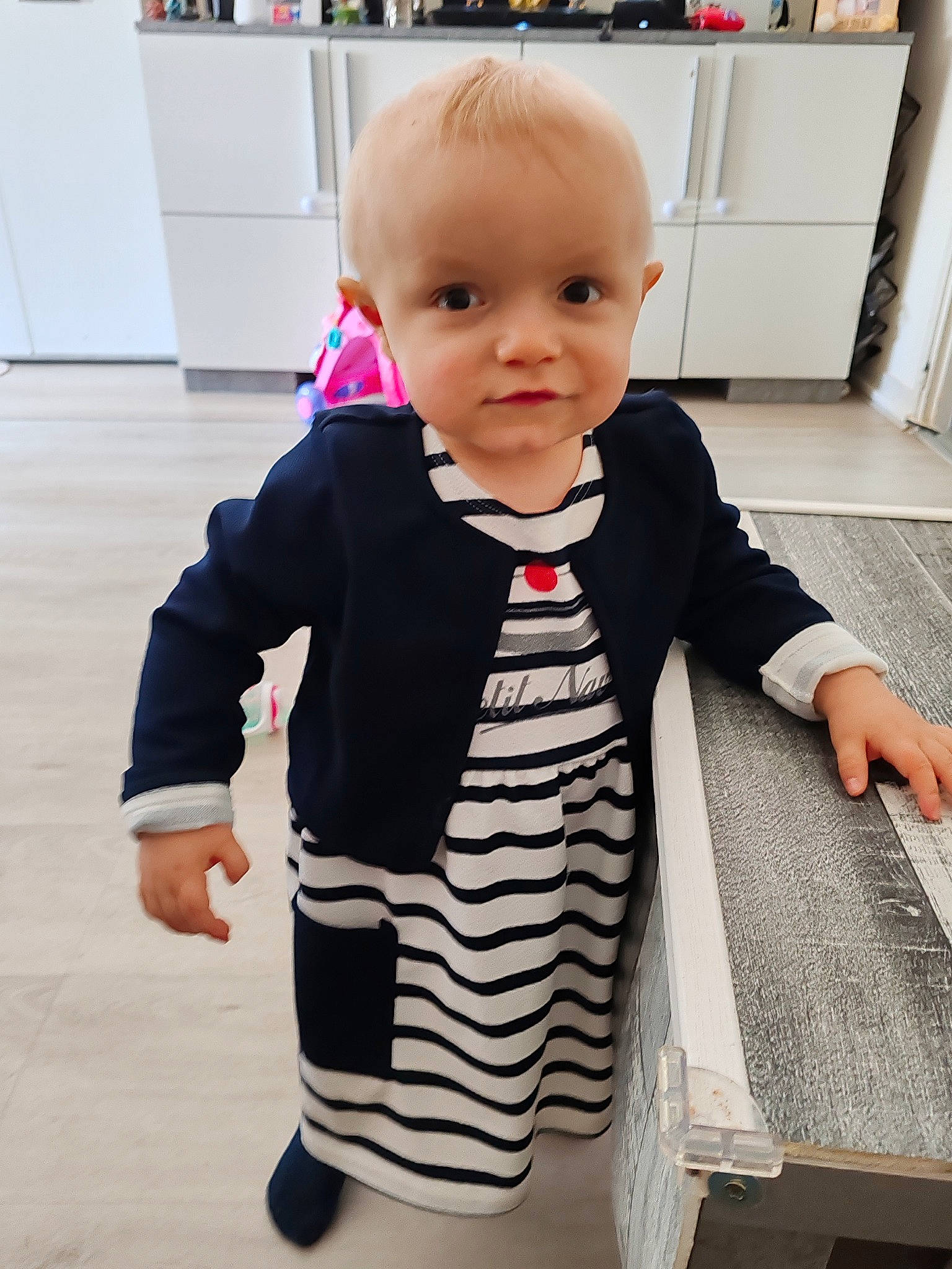 Louna participe au concours pour gagner de l'argent avec cette photo : baby, baby_toddler_clothing, cheek, child, cleanliness, collar, fashion_design, flooring, happy, outerwear, pattern, person, room, shelf, skin, sleeve, t_shirt, thumb, toddler