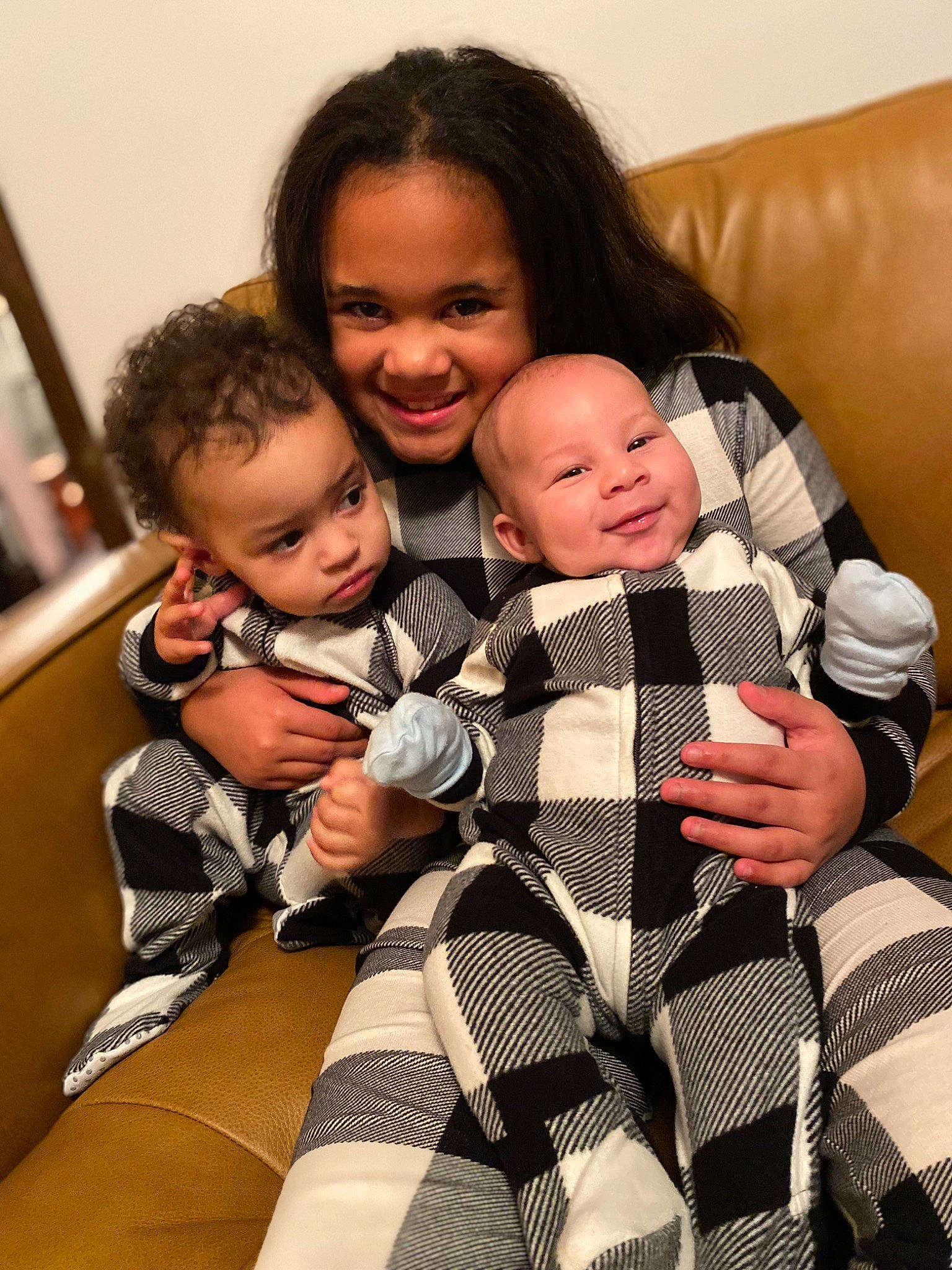 Kira is registered to the contest to win money with this photo: baby, baby_toddler_clothing, child, comfort, couch, facial_expression, finger, fun, gesture, hairstyle, happy, human, interaction, joy, pattern, person, sitting, skin, sleeve, smile