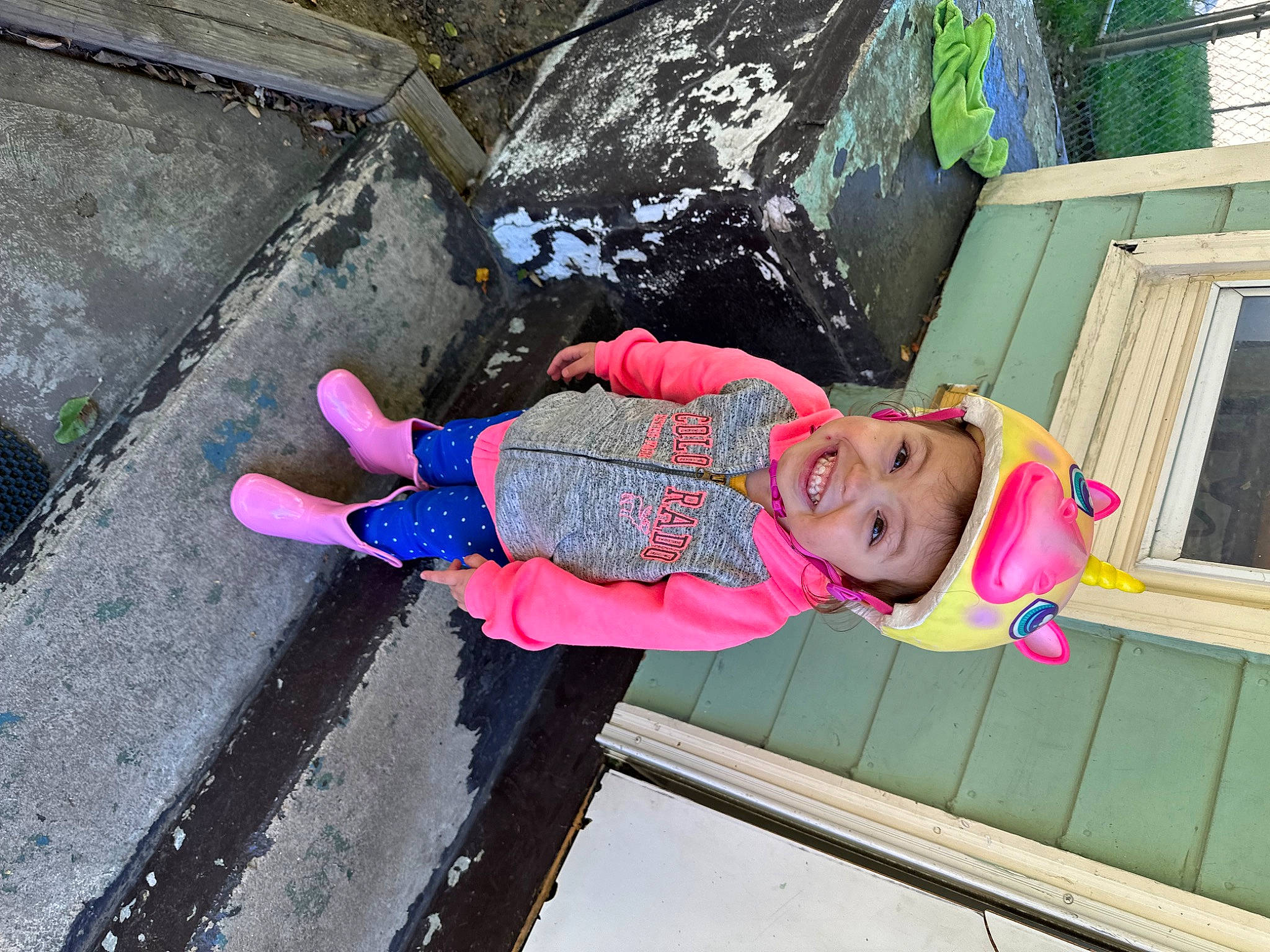 Eva is registered to the contest to win money with this photo: asphalt, baby_toddler_clothing, child, concrete, electric_blue, fun, happy, headwear, joy, leisure, magenta, person, pink, play, recreation, road_surface, sidewalk, smile, toddler, water