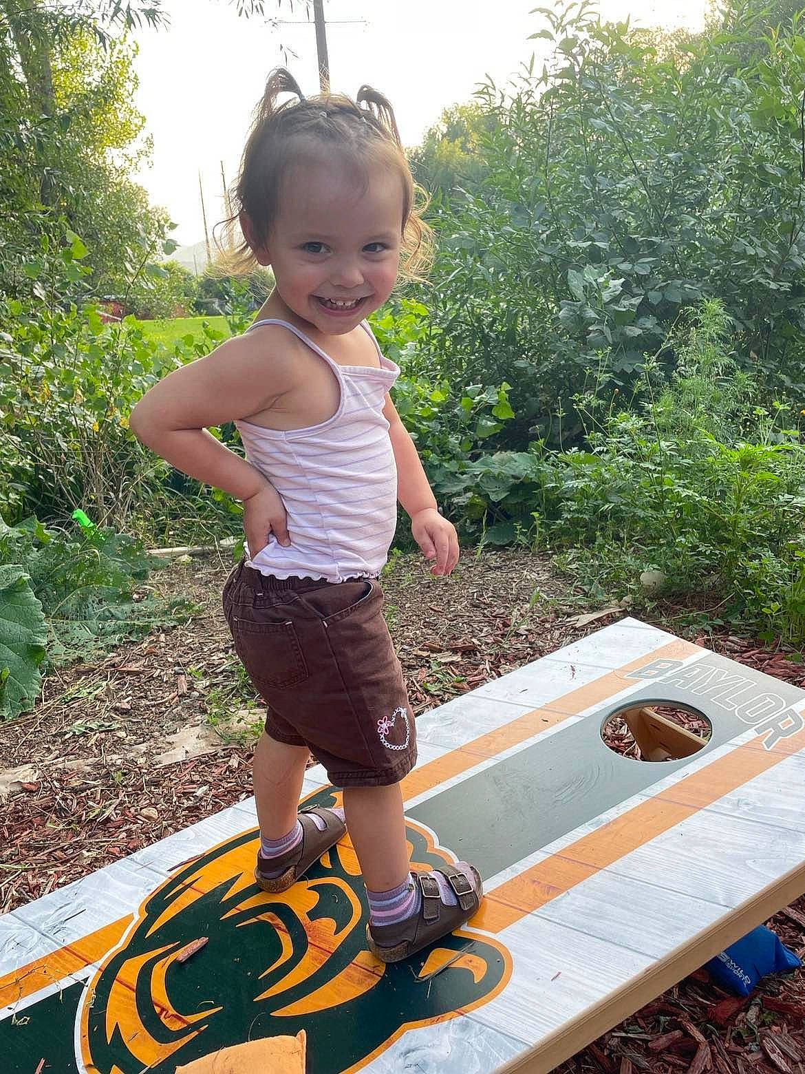 Eva is registered to the contest to win money with this photo: baby, baby_toddler_clothing, balance, barefoot, child, fun, garden, grass, happy, joy, leisure, people_in_nature, person, plant, play, recreation, shorts, soil, t_shirt, thigh