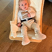 Damir a rejoint le concours — aidez-le/la à gagner de superbes lots ! baby, infant, child, face, wooden_floor, baby_seat, clothing, onesie, pants, slippers, drool, curious, indoors, cushion, wood, person, young, sitting, comfortable, cute