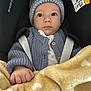 Damir a rejoint le concours — aidez-le/la à gagner de superbes lots ! baby, child, car_seat, blanket, knit_sweater, hat, blue_clothing, yellow_blanket, heart_pattern, wide_eyes, infant, cute, bundle, warm_clothing, seatbelt, indoor, portrait, person, face, hand