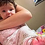 Matilda is registered to the contest to win money with this photo: baby, infant, child, person, arm, foot, toes, clothing, pajamas, blanket, indoor, wall, refrigerator, magnet, poster, cartoon, face, hair, skin, closeup