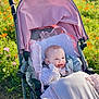 Delilah-Mae is registered to the contest to win money with this photo: baby, stroller, pink, blanket, flower_field, outdoor, sunny, child, happy, cozy, nature, greenery, grass, cute, infant, smiling, daylight, clothing, padded, relaxing