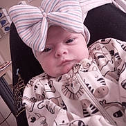 Nevaeh is registered to the contest to win money with this photo: newborn, baby, infant, child, portrait, face, eyes, bow, headband, striped, clothing, blanket, animal_print, cozy, reclining, indoor, chair, home, sleepy, cute