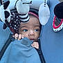 Iris is registered to the contest to win money with this photo: baby, child, stroller, blue, plush_toys, black_and_white, hands, face, eyes, hood, zipper, fabric, cute, infant, outdoor, soft_toys, curious, close_up, person, comfort