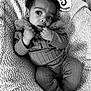 Iris is registered to the contest to win money with this photo: baby, infant, child, black_and_white, portrait, knitwear, blanket, milestone_card, 5_months, bow, socks, texture, cute, cozy, lying_down, hands, face, eyes, expression, indoor