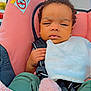 baby, infant, car_seat, pink, bib, clothing, curly_hair, child, seatbelt, hand, footwear, knit_socks, outdoor, portrait, person, cute, small, young, toddler, resting