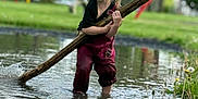 Phoenix joined the competition — help win amazing prizes! blonde_hair, casual_clothing, child, daytime, fun, grass, greenery, nature, outdoor, person, playing, pond, puddle, reflection, relaxation, splash, stick, trees, water, young