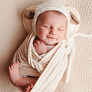 Liam a rejoint le concours — aidez-le/la à gagner de superbes lots ! baby, newborn, infant, sleeping, smile, swaddled, knit_hat, ear_detail, toes, feet, blanket, textured_background, cozy, soft_light, portrait, close_up, peaceful, cute, studio, warm_tones