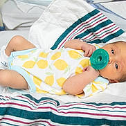 Thomas Ricci Jr is registered to the contest to win money with this photo: newborn, baby, pacifier, hospital_bassinet, onesie, lemon_pattern, socks, blanket, striped_blanket, infant, lying_down, baby_clothing, hospital, sleepy, cute, small_arms, small_legs, skin, face, resting