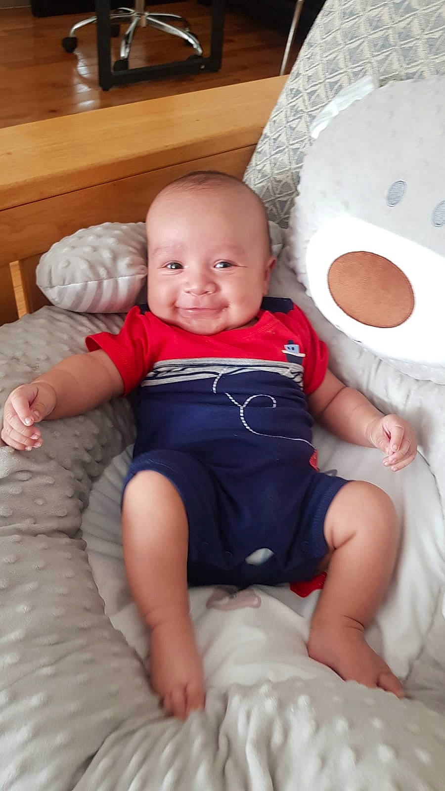 Athan is registered to the contest to win money with this photo: baby, baby_toddler_clothing, cheek, child, comfort, finger, flooring, fun, human_leg, joy, knee, lap, leg, linens, person, sitting, skin, smile, thigh, toddler