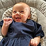 Ava-Mae is registered to the contest to win money with this photo: baby, child, closeup, cushion, cute, dress, expression, hand, happy, head, indoor, infant, person, portrait, seat, skin, small_hands, smiling, soft_furniture, young_child