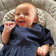 Ava-Mae is registered to the contest to win money with this photo: baby, child, closeup, cushion, cute, dress, expression, hand, happy, head, indoor, infant, person, portrait, seat, skin, small_hands, smiling, soft_furniture, young_child