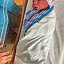 newborn, baby, hospital, blanket, bassinet, infant, swaddled, bed, person, hat, hand, medical, healthcare, cute, sleeping, newborn_care, striped_hat, soft, tender, resting