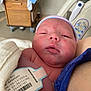 Charles is registered to the contest to win money with this photo: newborn, baby, infant, hospital, blanket, id_bracelet, bed, medical_equipment, person, head, face, skin, sleepy, clothing, human, indoors, patient, healthcare, closeup, resting