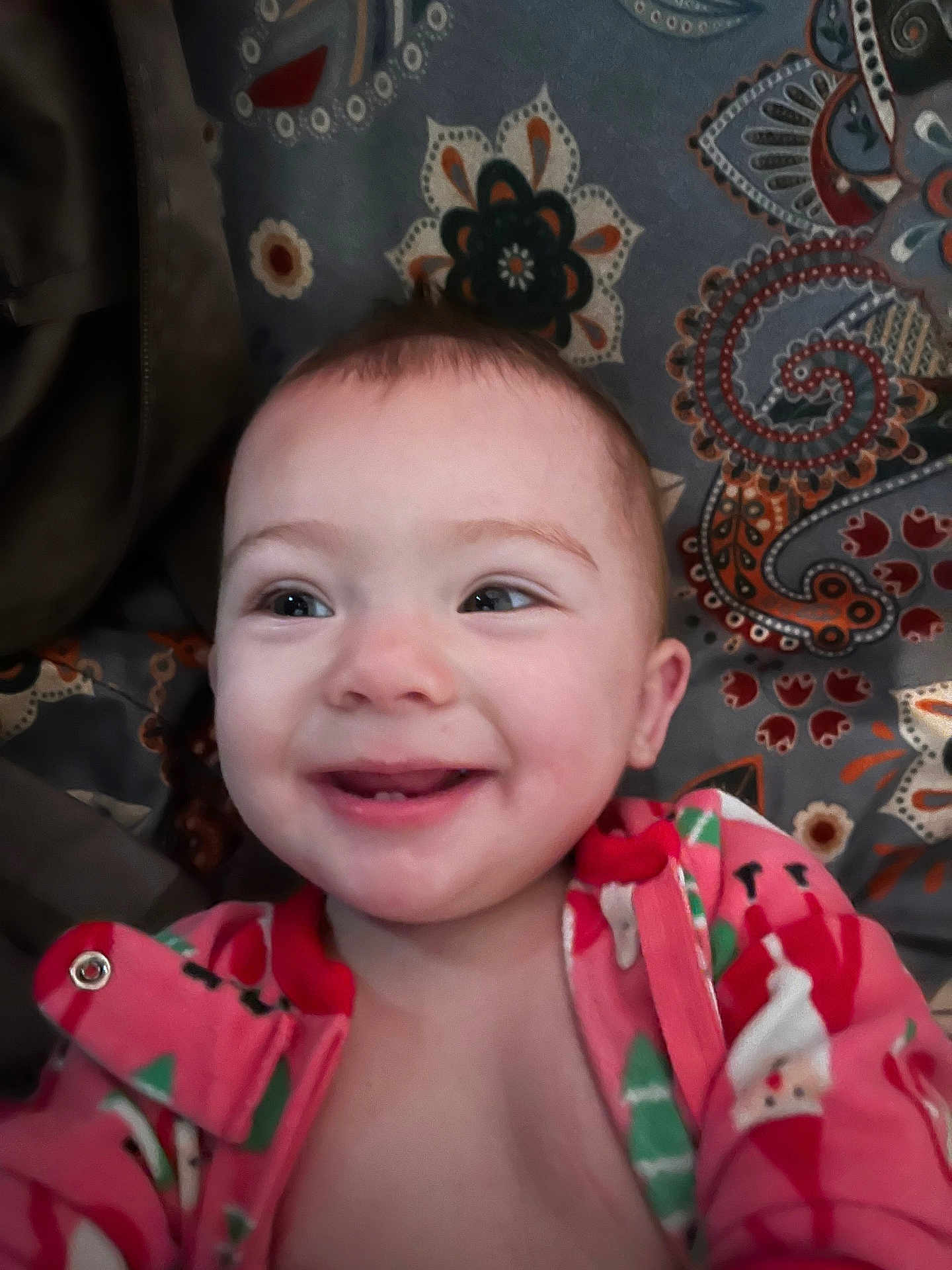 Ellie joined the competition — help win amazing prizes! baby, smile, infant, child, face, onesie, clothing, happy, patterned_background, close_up, young_child, portrait, cute, indoors, baby_girl, cheerful, colorful, fabric, head, skin