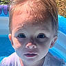 Ellie is registered to the contest to win money with this photo: toddler, child, water, wet, face, blue_pool, outdoor, summer, curious, closeup, water_droplets, young_child, playing, inflatable_pool, sunlight, grass, short_hair, white_shirt, portrait, daytime