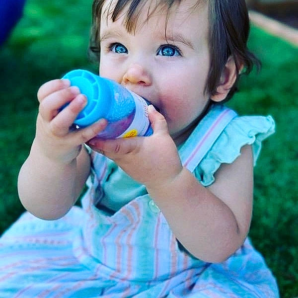 Taylor is registered to the contest to win money with this photo: baby_toddler_clothing, blue, drinkware, electric_blue, face, finger, fun, gesture, grass, green, happy, leisure, liquid_bubble, nail, nose, people_in_nature, person, plastic_bottle, thumb, toddler