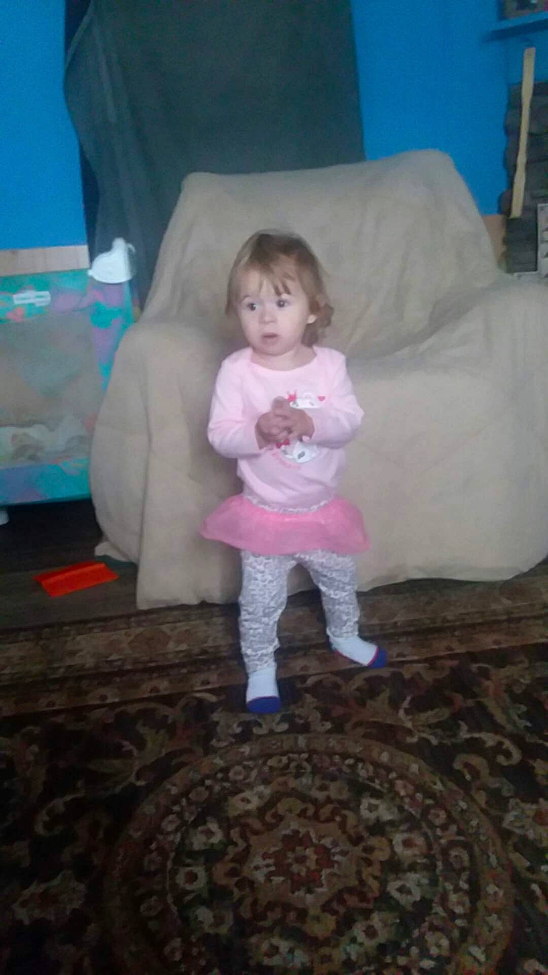 Karolina is registered to the contest to win money with this photo: baby, baby_toddler_clothing, child, comfort, eye, floor, flooring, fun, hair, human_body, human_leg, linens, person, pink, play, room, sitting, sleeve, standing, surprise