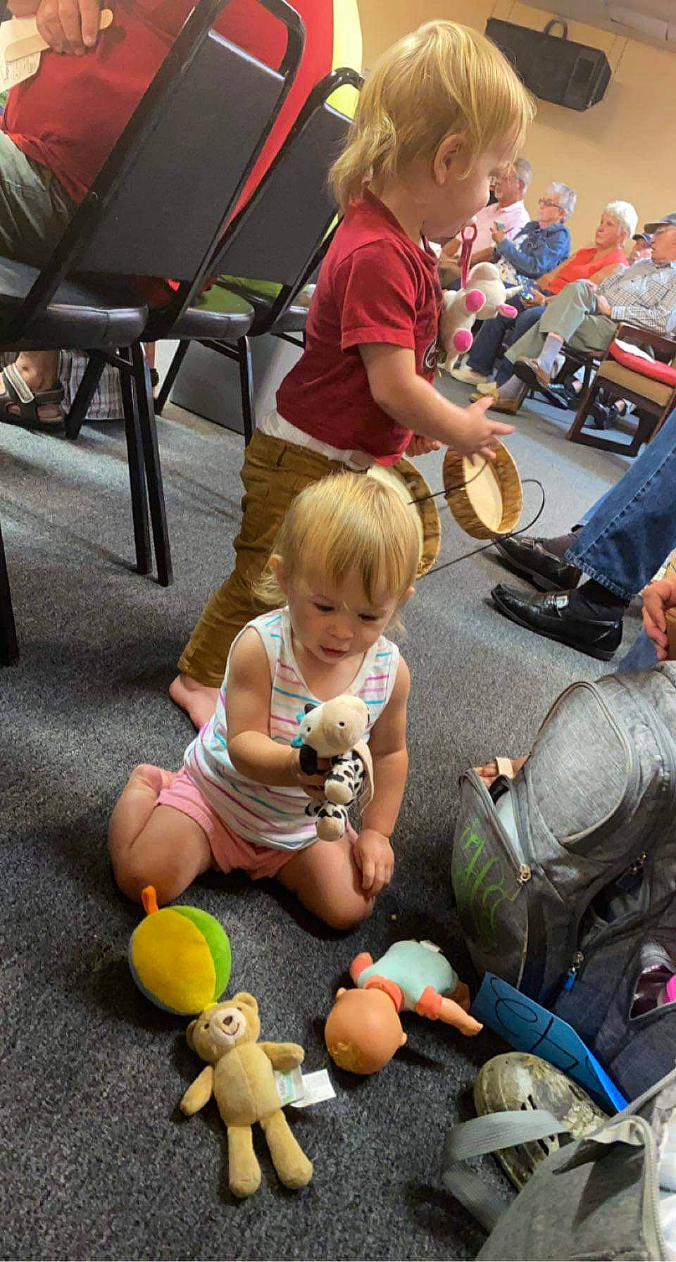 Karolina is registered to the contest to win money with this photo: chair, child, event, fun, grass, hat, jeans, lap, leg, leisure, people, person, photograph, public_space, recreation, shorts, sitting, snapshot, sneakers, toddler