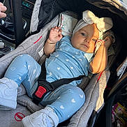 Chelsea participe au concours pour gagner de l'argent avec cette photo : baby, car_seat, infant, child, blue_clothing, headband, bow, white_shoes, car_interior, seatbelt, hand, steering_wheel, sunlight, shadow, face, portrait, comfort, sitting, vehicle, casual