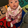 baby, child, infant, plaid_clothing, pink, bib, socks, play_mat, numbers, letters, curious, wide_eyes, sitting, indoors, floor, cute, portrait, person, young_child, colorful
