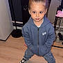 Mylann a rejoint le concours — aidez-le/la à gagner de superbes lots ! child, young_child, hoodie, jeans, sneakers, indoor, wooden_floor, standing, hands_in_pockets, top_bun, casual_clothing, speaker, floor, person, fashion, cute, home, expression, portrait, confident