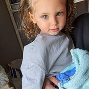 Mylann a rejoint le concours — aidez-le/la à gagner de superbes lots ! child, toddler, curly_hair, headband, blanket, holding, indoor, bed, bunk_bed, person, green_eyes, clothing, hand, adult, room, soft_texture, casual, portrait, cute, candid