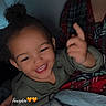 toddler, child, smiling, happy, curly_hair, blanket, indoor, cozy, person, plaid_shirt, adult, bed, sleepwear, pointing, face, portrait, cute, dim_lighting, family, casual