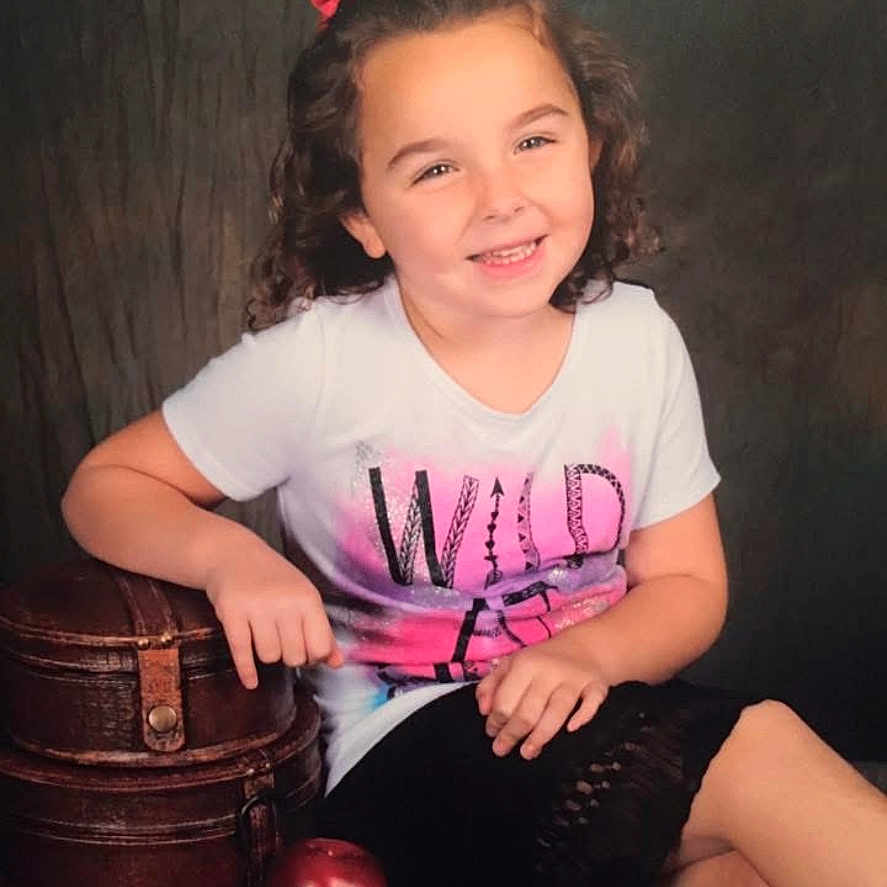 Ashlynn is registered to the contest to win money with this photo: accessories, bag, bodypart, child, clothing, face, female, finger, girl, hand, handbag, happy, hat, head, person, photography, portrait, shorts, smile, t_shirt